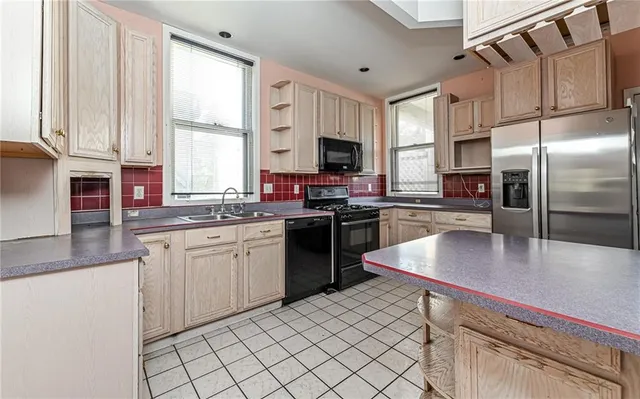 a kitchen with stainless steel appliances granite countertop a sink a stove and a refrigerator
