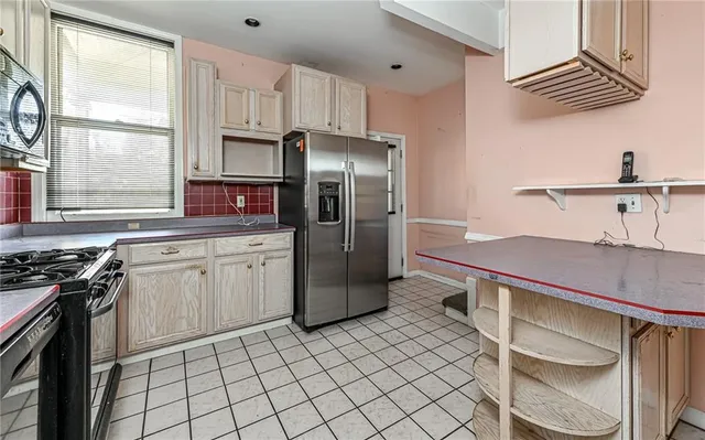 a kitchen with stainless steel appliances a stove a sink and a refrigerator