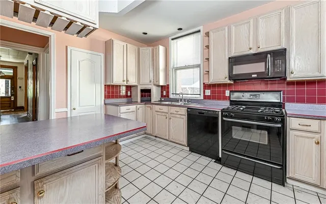 a kitchen with stainless steel appliances a stove a sink and a microwave