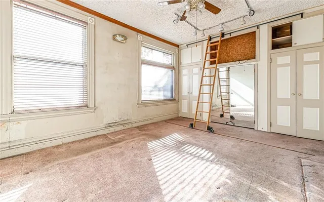 a view of a bedroom with a bed and wooden floor