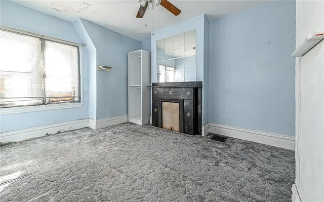 an empty room with windows and fireplace