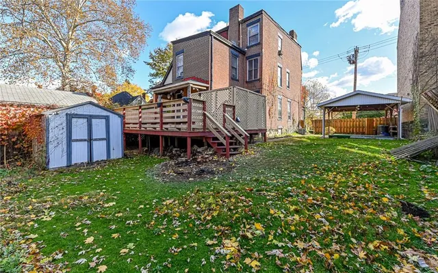 a view of a house with a big yard and large trees