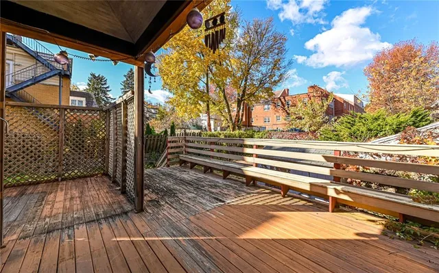 a view of a tiny house with a small yard and wooden fence