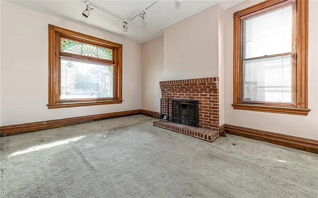 an empty room with windows fireplace and windows