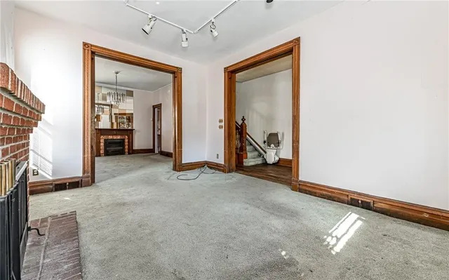 an empty room with windows and a ceiling fan