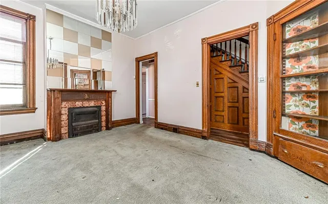 an empty room with windows and fireplace