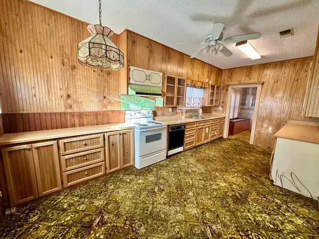 a large kitchen with kitchen island granite countertop a sink and cabinets