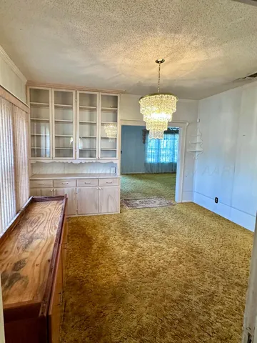 a room with chandelier and windows