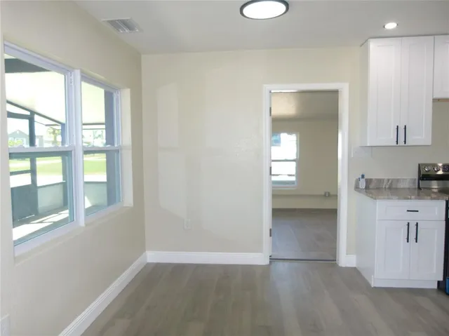an empty room with windows and cabinet