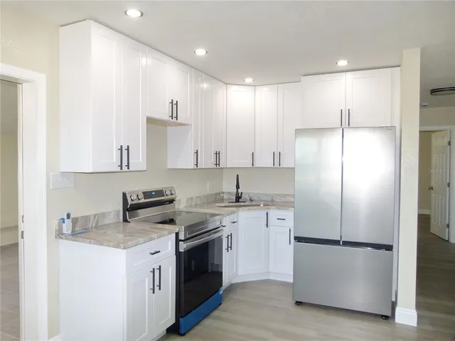 a kitchen with a refrigerator sink and cabinets