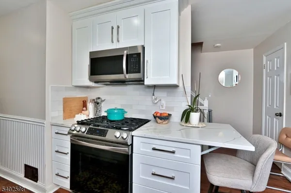 a kitchen with stainless steel appliances a stove a microwave a sink and cabinets