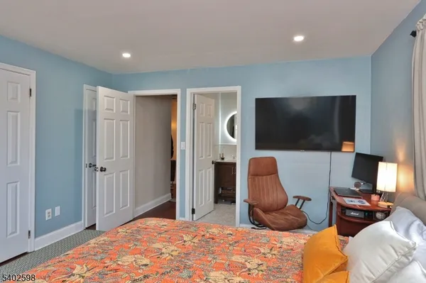 a bedroom with furniture and a flat screen tv