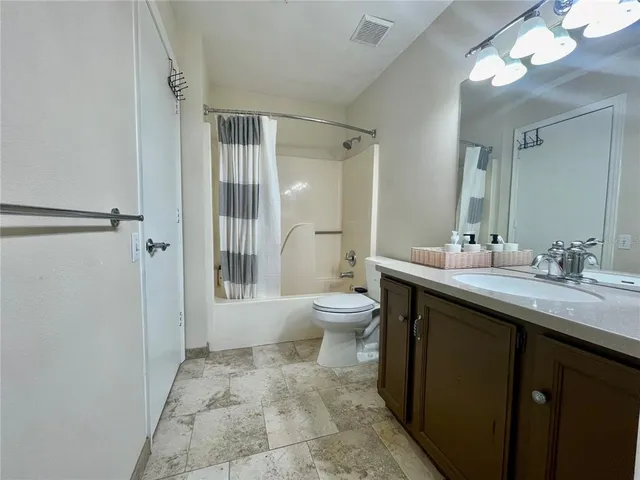 a bathroom with a granite countertop sink toilet a shower and a mirror
