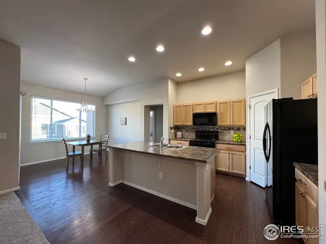 a view of a dining room and livingroom with furniture wooden floor a chandelier