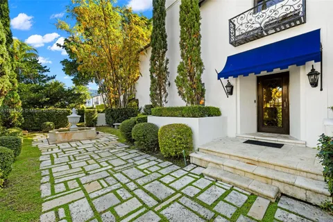 a view of a patio with table and chairs potted plants and a fountain