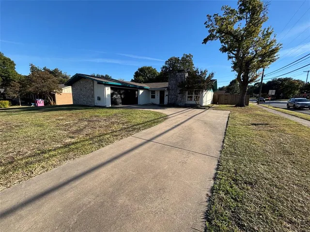 a front view of a house with a yard and trees