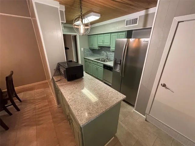 a kitchen with stainless steel appliances granite countertop sink refrigerator and microwave