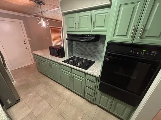 a kitchen with cabinets and a stove top oven