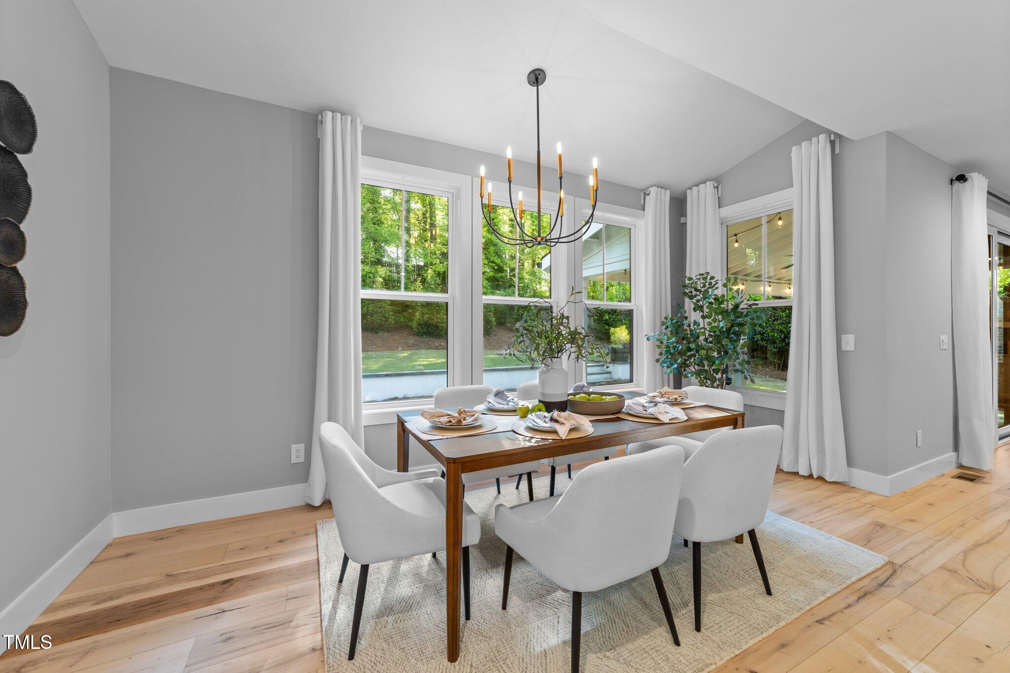 3316 Milton Road Raleigh, NC 27609 - Photo 18 of 50 a dining room with furniture a chandelier and wooden floor