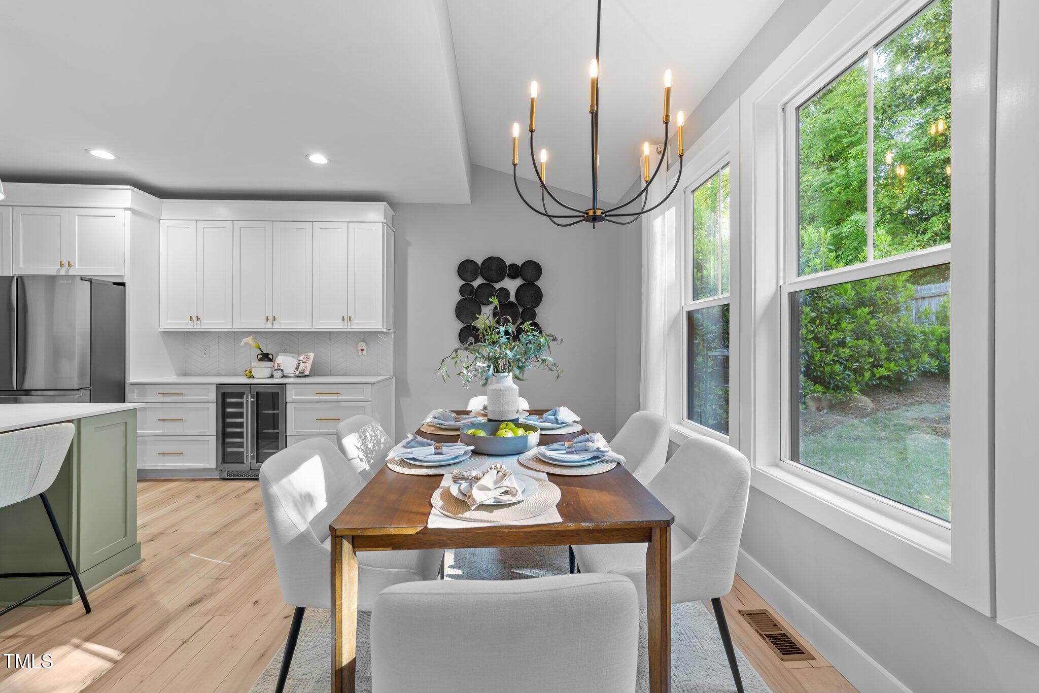 3316 Milton Road Raleigh, NC 27609 - Photo 20 of 50 a view of a dining room with furniture a chandelier and wooden floor