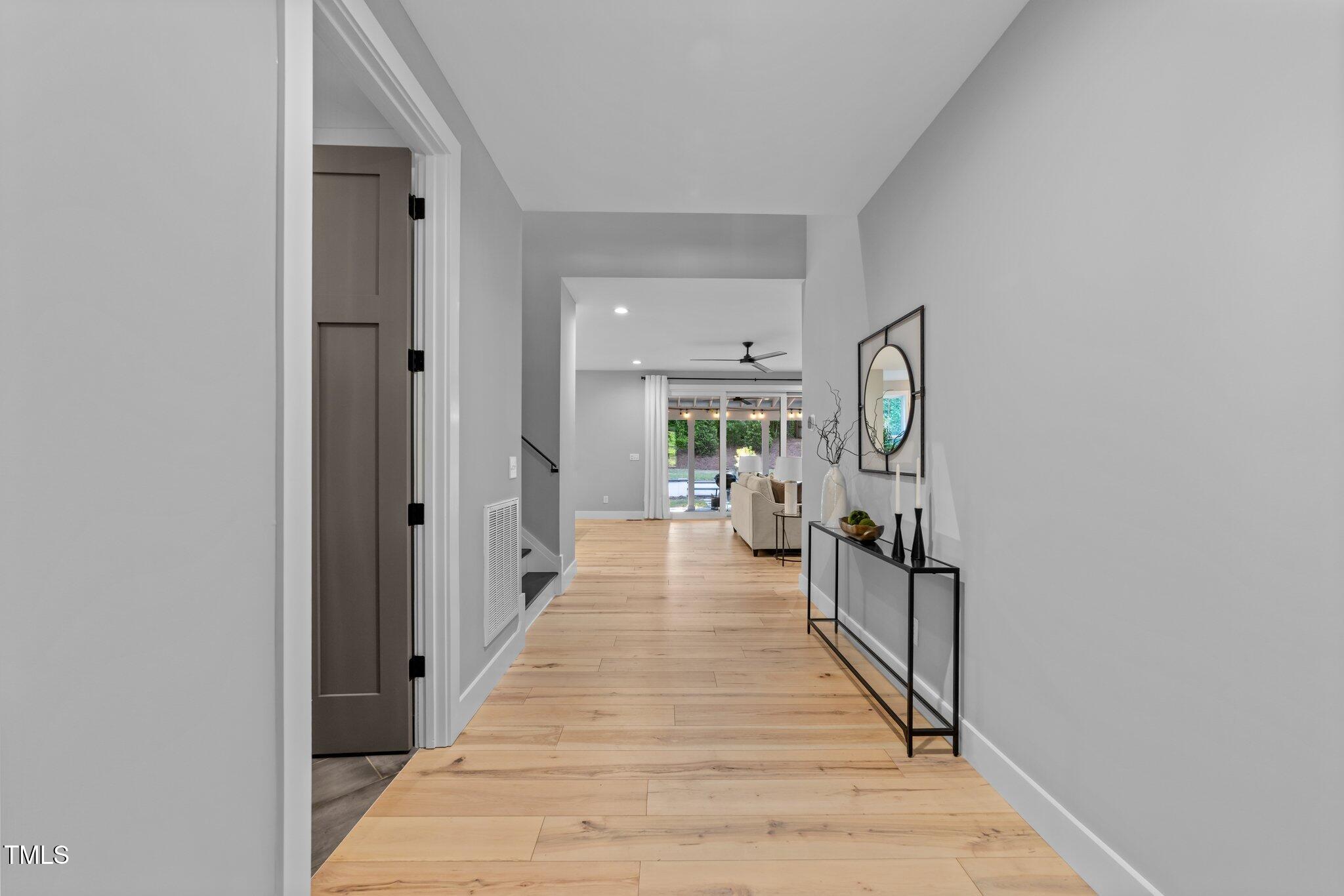 3316 Milton Road Raleigh, NC 27609 - Photo 3 of 50 a view of a hallway with the wooden floor and a living room