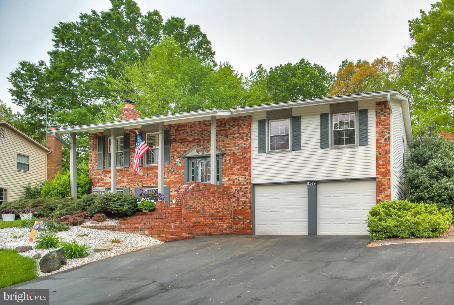 9148 Rockefeller Lane Springfield, VA 22153 - Photo 2 of 29 a front view of a house with garden