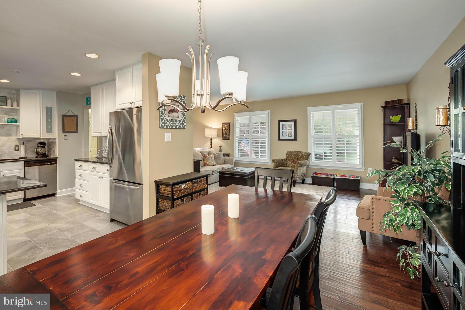 9148 Rockefeller Lane Springfield, VA 22153 - Photo 11 of 29 a kitchen with stainless steel appliances a dining table chairs stove refrigerator and wooden floor