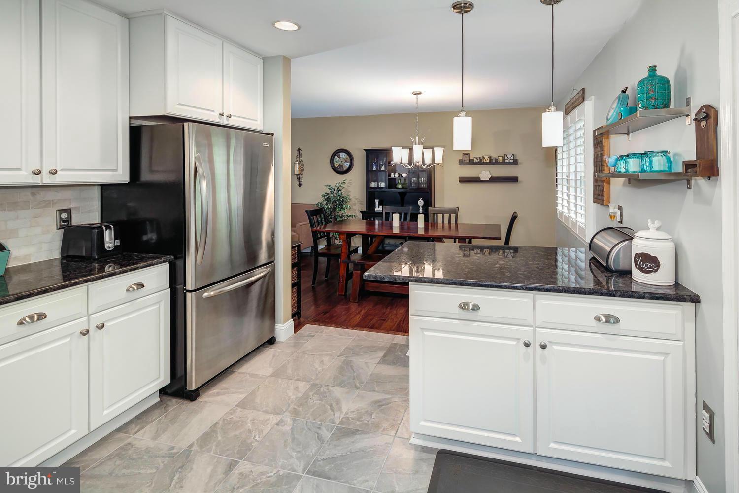 9148 Rockefeller Lane Springfield, VA 22153 - Photo 12 of 29 a kitchen with stainless steel appliances granite countertop a refrigerator a sink a stove and white cabinets