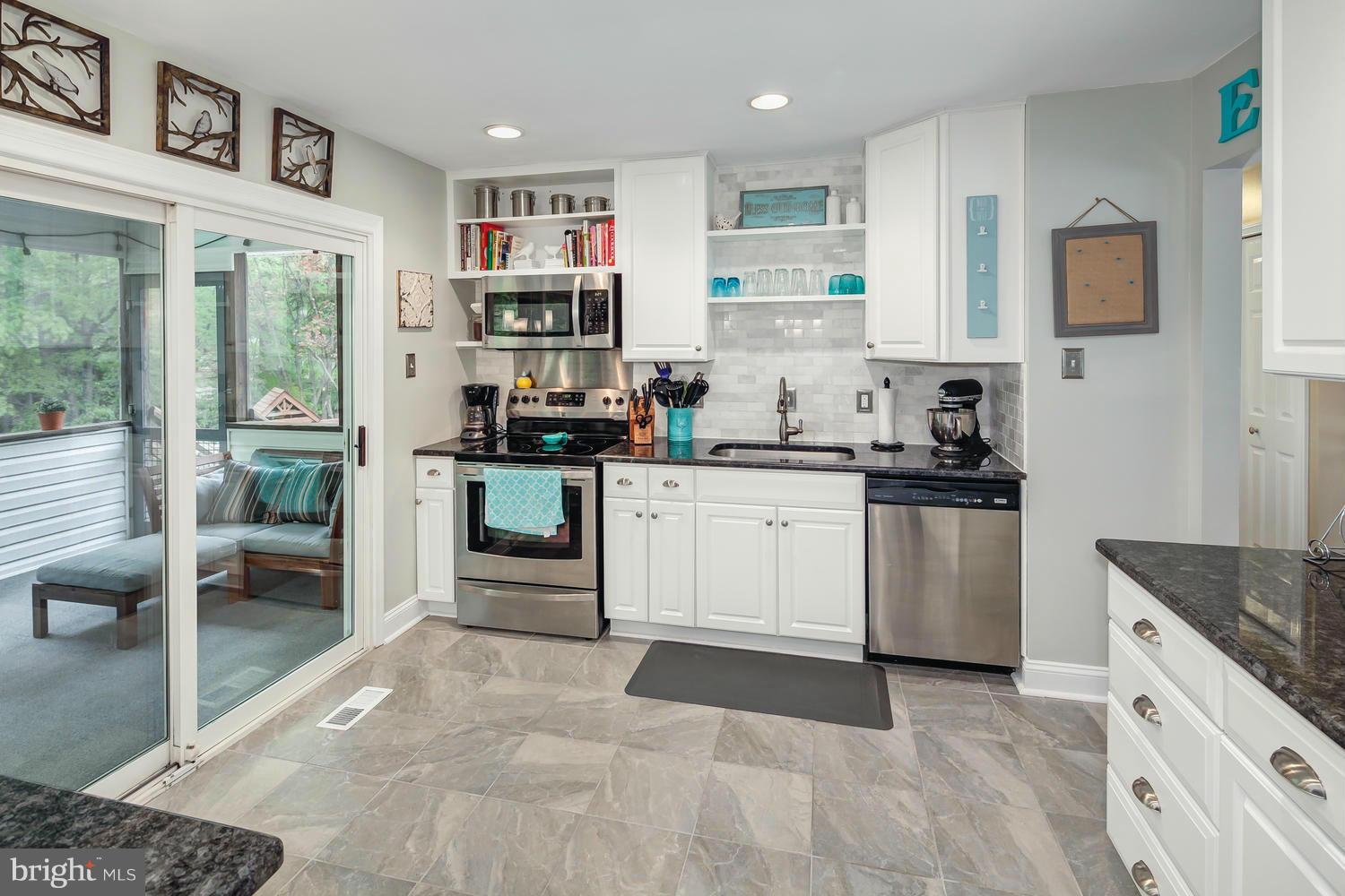 9148 Rockefeller Lane Springfield, VA 22153 - Photo 14 of 29 a kitchen with stainless steel appliances granite countertop a stove top oven a sink a refrigerator and white cabinets