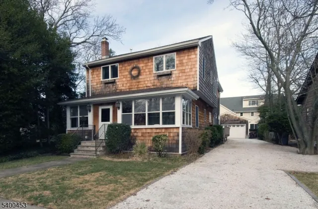 a front view of a house with a yard and trees