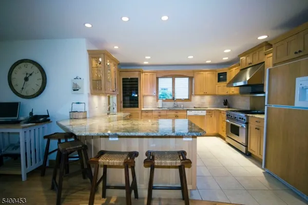 a kitchen with granite countertop kitchen island stainless steel appliances a table and chairs