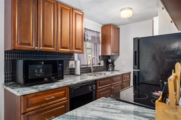 a kitchen with stainless steel appliances granite countertop a stove a sink and a microwave