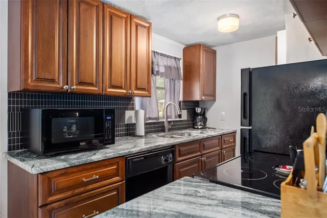 a kitchen with stainless steel appliances granite countertop a stove a sink and a microwave