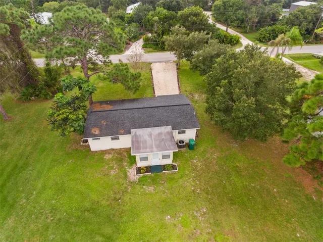 an aerial view of a house with a yard swimming pool and outdoor seating