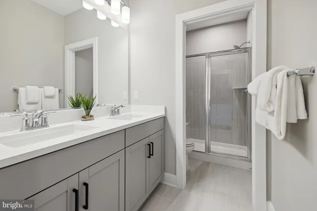 a bathroom with a double vanity sink mirror and shower