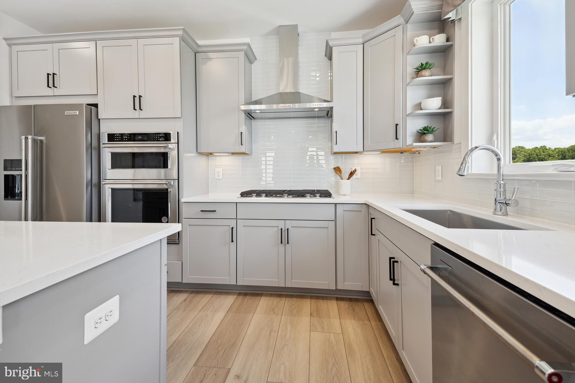 14404 Dowitcher Way Boyds, MD 20841 - Photo 7 of 54 a kitchen with cabinets a sink and stainless steel appliances
