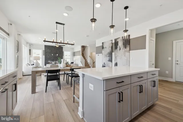 a kitchen with stainless steel appliances kitchen island a large island in the center and wooden floors