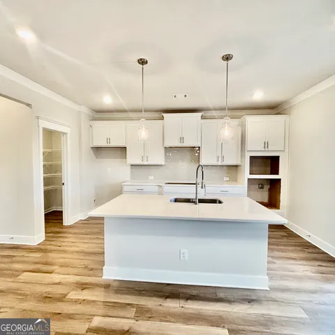 a kitchen with a sink a stove and white cabinets
