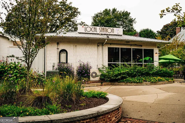 a front view of a building with cars parked