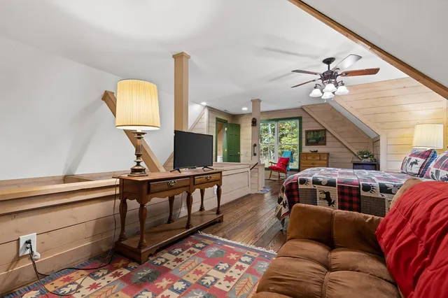 a living room with furniture a flat screen tv and large window
