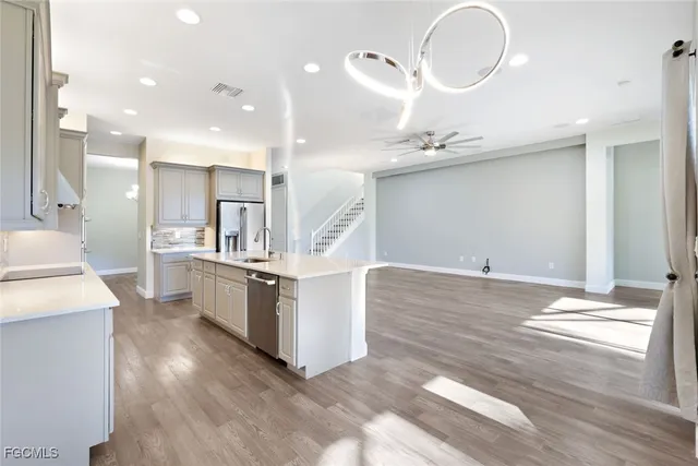 a large white kitchen with lots of counter space wooden floor and appliances