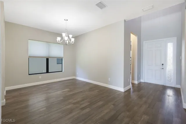 an empty room with wooden floor and mirror