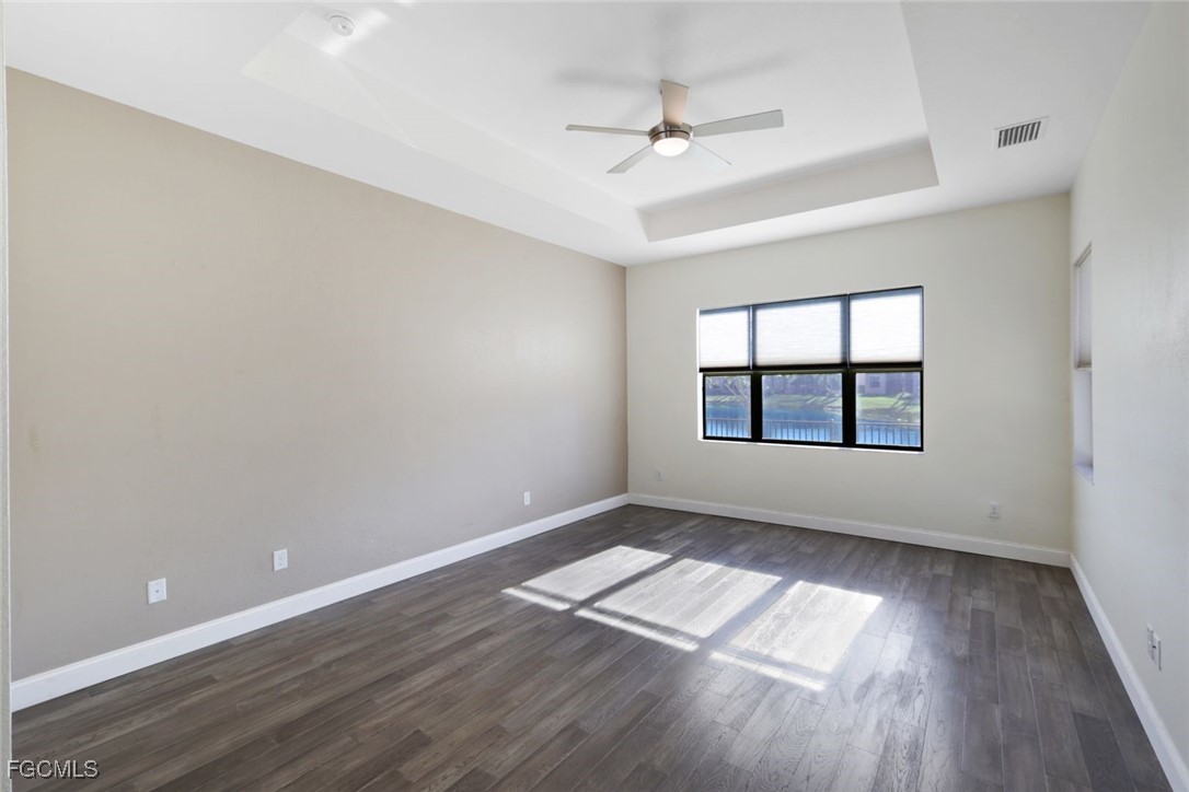 11727 Kati Falls Lane Fort Myers, FL 33913 - Photo 20 of 48 an empty room with wooden floor chandelier fan and windows