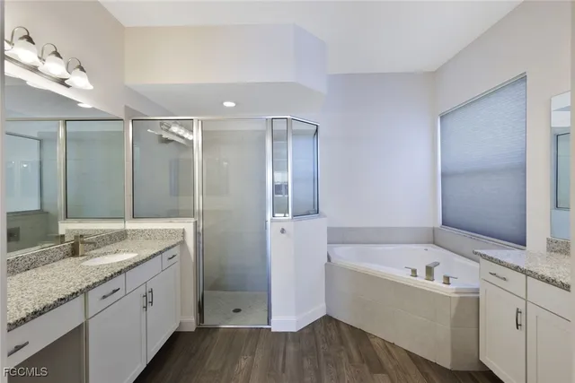 a bathroom with a granite countertop tub sink and mirror