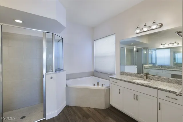 a bathroom with a granite countertop sink mirror and bathtub