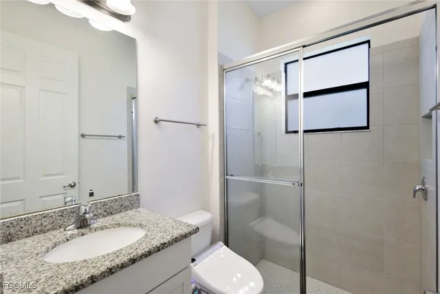 a bathroom with a granite countertop sink toilet and shower