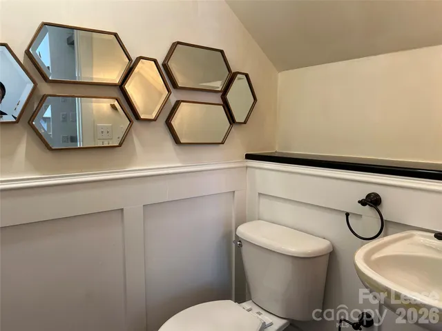 a bathroom with a toilet mirror and sink