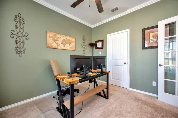 a view of a workspace with furniture and a window