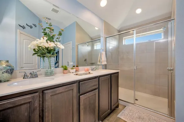 a en suite bathroom with a double vanity sink and a mirror