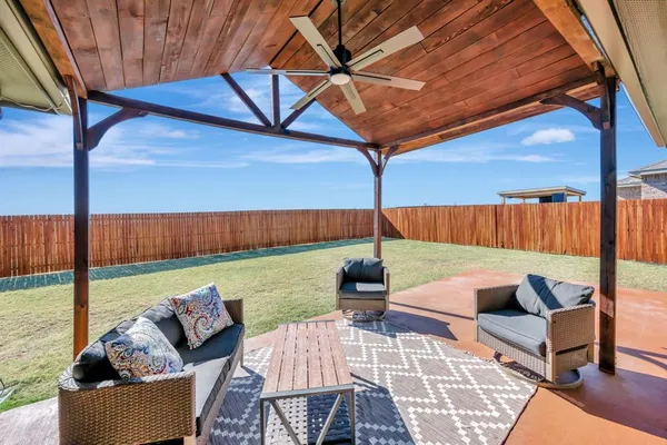a view of a patio with a table chairs and wooden floor